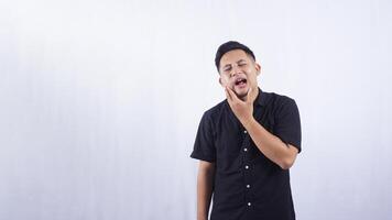 Unhealthy Young Asian Man Suffering from Strong Toothache on White Background photo