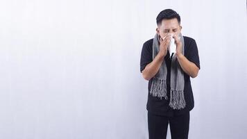 Asian Man Blows His Nose with Tissue Paper Suffering from Flu on White Background photo