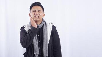 Young Asian Man with Swollen Cheek Suffering from Toothache on White Background photo