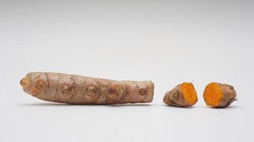 Pieces of Turmeric Spice on White Background photo