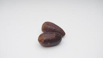 Two Nutmegs Spice on White Background photo