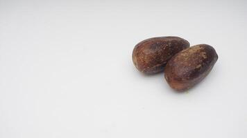 A Pair of Nutmegs Spice on White Background photo