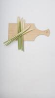 Fresh Lemongrass on Wooden Cutting Board on White Background photo