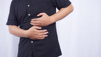 Close Up of Man Touching on His Stomach Suffering from Stomach Pain on White Background photo