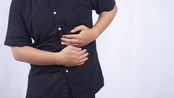 Close Up of Man Touching on His Stomach Suffering from Abdominal Pain on White Background photo