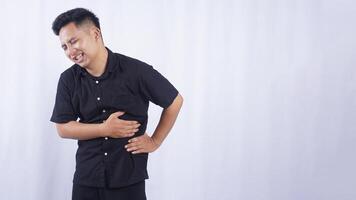 Asian Man Touching on His Stomach Suffering from Stomachache on White Background photo