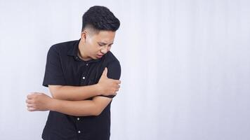 Asian Man Suffering from Stiff Muscle on White Background photo