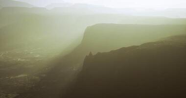 Cliff at dawn with mist and sunlight in a serene landscape video