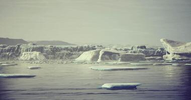 Icebergs float serenely in calm waters during a quiet morning in the Arctic video