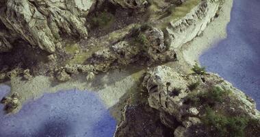 Explore the rocky coastline with tranquil waters and lush greenery video