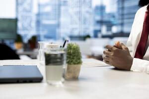 HR staff member reviewing candidate resume while asking questions about qualifications. Close up of man at office desk proving skills during interview, showcasing enthusiasm for job opportunity photo