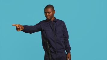 Security guard pointing finger at people to prevent them from gaining access in restricted areas. Portrait of stern bodyguard scolding and telling off unwanted visitors, studio background, camera B photo