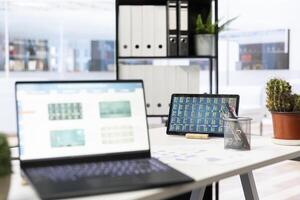 Empty financial department with stock portfolio on laptops and paperwork files filled with marketing charts. Close up shot of forex exchange indices on notebook device screen photo