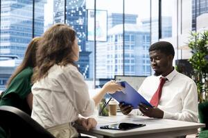 HT staff members checking if job candidate qualifications are aligned with company expectations. Human resources employees verifying resume before agreeing terms with job applicant photo