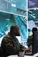 Government intelligence officers in a high tech command post oversee satellite data, manage real time surveillance footage via radar cctv and coordinate operations. Protecting national interests. photo