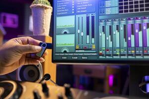 Sound designer copying audio recordings from an usb stick to start editing the tracks in post production, workstation in home studio. Mixing and mastering songs for the music industry. Close up. photo