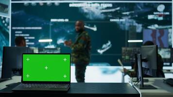Army IT expert in control center collecting real time battlefield data, process satellite surveillance imagery for successful military defense mission. Using green screen isolated display. Camera B. photo