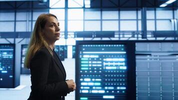 Engineer inspecting server room hardware, walking between supercomputers. IT professional supervising data center workplace, checking equipment, monitoring performance, camera A photo