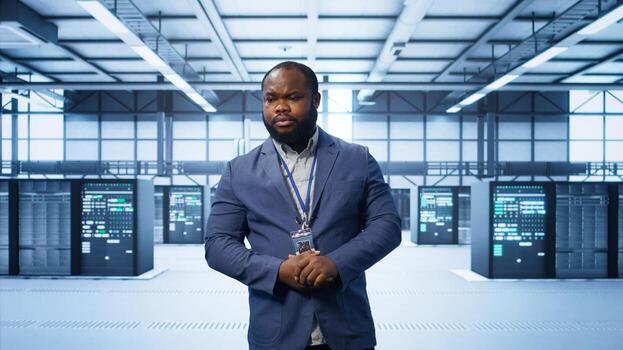 Technician walking between server rows in data center, doing yearly infrastructure inspection. System administrator in server hub monitoring supercomputers equipment, camera B photo