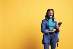 Portrait of happy woman holding laptop, preparing to start work shift, isolated over studio background. Cheerful employee with notebook ready to do business related tasks on it photo