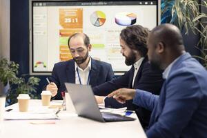 Startup employees exchanging project details and essential information about achieving business goals, establishing budget and other resources. Management team sharing information in a meeting. photo