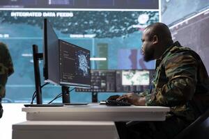 IT professional gathering real time intelligence from radar systems in military control tower, processing surveillance footage and transmitting crucial information to help with mission success. photo