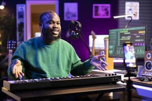 Famous piano teacher conducting internet master class via vlog tutorial, teaching people how to hit the right notes on electronic keyboard. Young artist performer hosts synthesizer lessons. photo