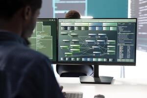 Governmental hacker expert securing computer systems from cyber attacks, working in monitoring center control room. Man focusing on encryption and espionage against cyber threats. photo