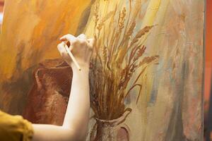 Artisan inspired by natural rural elements to paint a masterpiece on canvas, using modern paintbrushes in art studio. Working with motivation and creativity for fine art creative process. Close up. photo