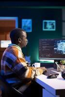 African american IT professional managing AI system for machine learning, coding software on terminal window. Futuristic interface program focuses on cyber security, networking for database. photo