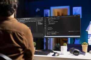 Man working from home implementing security measures to protect company systems and data. Tech support IT worker writing, testing and debugging code for software applications photo