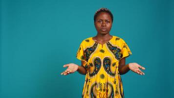Uncertain woman acting confused and raising shoulders in studio, being clueless and making an i dont know sign. Indecisive unsure person feels doubtful, something ambiguous. Camera B. photo