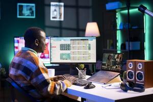 African American man having discussion during online meeting on laptop, talking about internet statistics or data. Male freelancer use technology for virtual communication, working remotely. photo