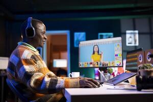 Black man photo editor in a well organized workspace editing images on dual monitors using advanced software tools, displaying creativity and professional dedication. Computer setup.