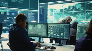 Governmental hackers analyzing big data for cyber threat detection, working at agency desks. Professional expert woman analyzes cyber intelligence and prevention of digital threats. Camera B. photo