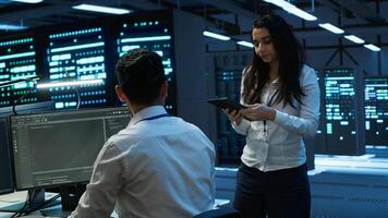 Coworkers in high tech data center monitoring security threats, implementing cybersecurity measures. IT staff members ensuring compliance with server room workspace regulations photo
