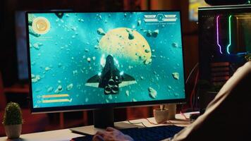 Man using gaming keyboard to fly spaceship in SF videogame, close up on computer screen. Gamer using powerful PC and computer peripherals to compete in science fiction multiplayer game tournament photo