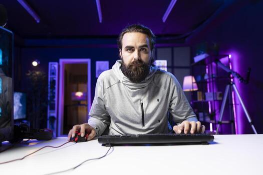 Focused man using gaming mouse and keyboard to shoot enemies in videogame. Gamer using powerful PC and computer peripherals, concentrating on competing in multiplayer game photo