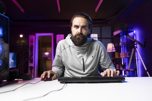 Content creator sitting on gaming chair filming tutorial for audience on how to defeat enemies in multiplayer game. Pro player playing videogame, teaching viewers esports strategies photo