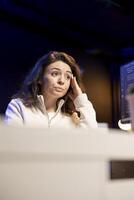 Worried cybersecurity expert rubbing head temples after finding many security vulnerabilities, scared of malware infections. Anxious developer distressed by cyber attacks on computer systems photo