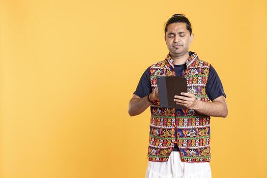 Man upset after lacking necessary money while trying to buy stuff online on tablet. Sad person looking at debit card after getting transaction rejected on device, studio background photo