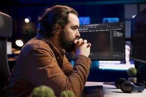 Pensive computer engineer thinking how to futureproof company network from downtimes and unexpected system failures. IT admin brainstorming ways to increase data security photo