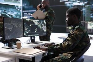 Military personnel in high tech control room work on data integration, processing real time surveillance and maintaining security protocols. Support national defense and army operations. photo