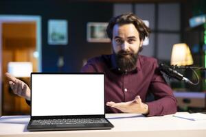 Portrait of tech specialist assessing mockup laptop performance, talking about parts used inside. Entertainer reviewing isolated screen notebook on technology internet channel photo