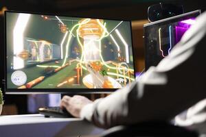 Man enjoying competitive online FPS videogame, battling flying robots with futuristic gun. Close up shot of gamer playing science fiction first person shooter game, fighting enemy boss photo
