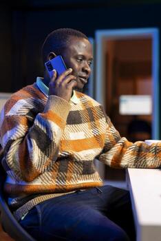 On a phone call from home, economist seeking to secure new financial support from investors. African american financial advisor operating remotely to increase earnings and lower expenses. photo