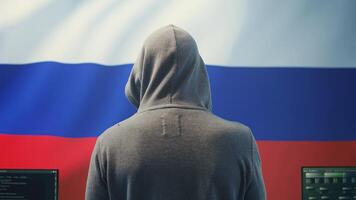 A Russian hacker working in a governmental hacking room with the Russian flag on big screen. Inflicting cyber terror, propaganda, fake news and misinformation in hybrid warfare. Camera B. photo