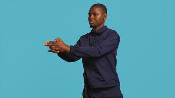 Portrait of security job employee shooting gun, detaining perpetrators while following legal protocols. Patrol guard follows conduct codes, doing pistol fingers gesturing, studio background, camera B photo