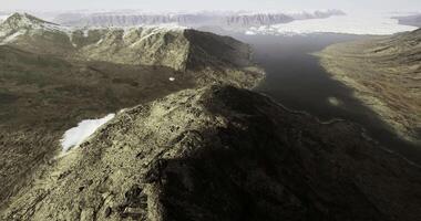 Expansive view of rocky terrain with water body and distant mountains video