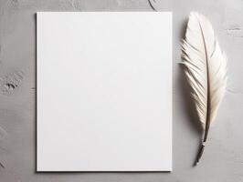 A blank sheet of paper beside a white feather on a textured surface. photo